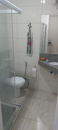 a bathroom with a toilet and a sink and a mirror at CHALÉ Pedaço do Coqueiro in Anchieta