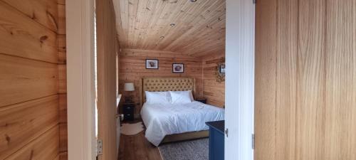 a bedroom with a bed in a wooden room at The Wellsprings Lodges and Restaurant in Clitheroe