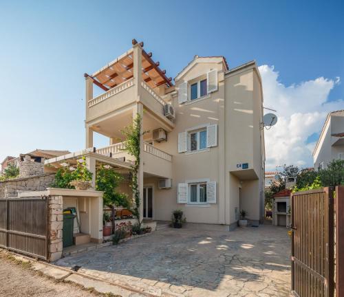 a villa with a gate in front of a house at Apartments Vucica, Sevid in Sevid