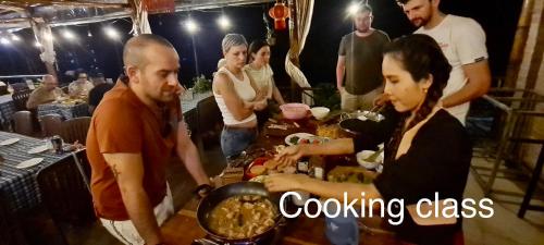 a group of people standing around a table preparing food at Song Ngư Riverside Homestay in Can Tho