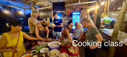 a group of people preparing food in a kitchen at Song Ngư Riverside Homestay in Can Tho