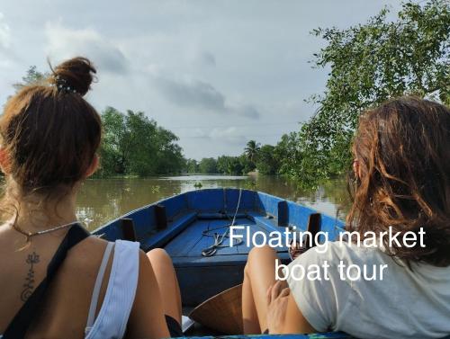 two women riding in a boat on a river at Song Ngư Riverside Homestay in Can Tho