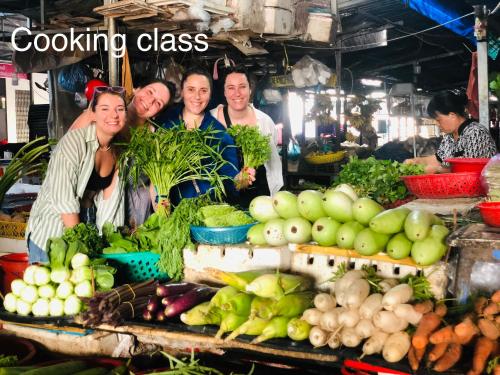 a group of people standing in a market with vegetables at Song Ngư Riverside Homestay in Can Tho