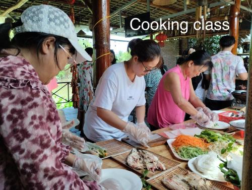 a group of people preparing food on a table at Song Ngư Riverside Homestay in Can Tho