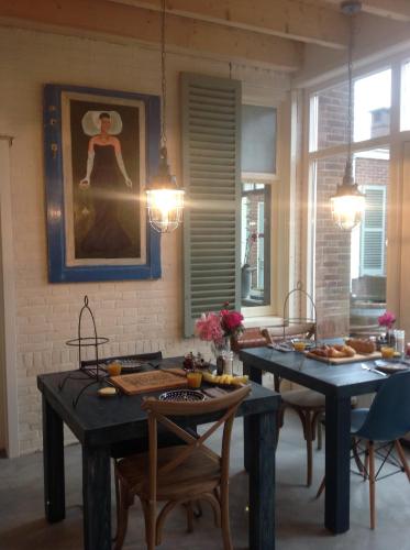 a kitchen with two tables and chairs and a painting at Sonop in Oostkapelle