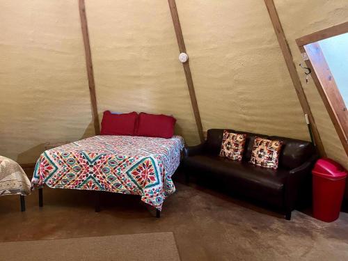 um quarto com um sofá, uma cama e uma cadeira em Sitting Bull - Tipi 6 em New Braunfels