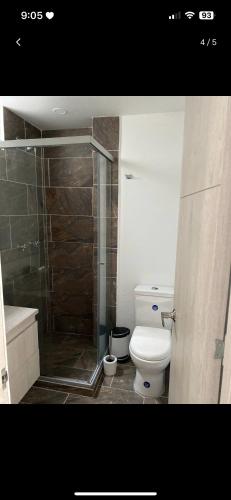 a bathroom with a toilet and a glass shower at Habitación con baño Privado in Envigado