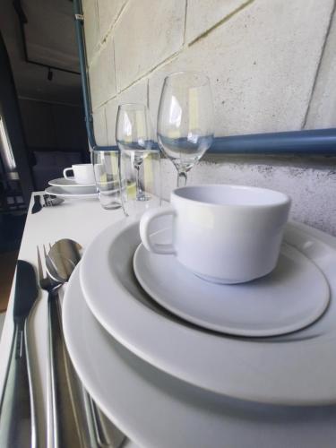 a table with white plates and wine glasses on it at Container Guesthouse - 2 in Urubici