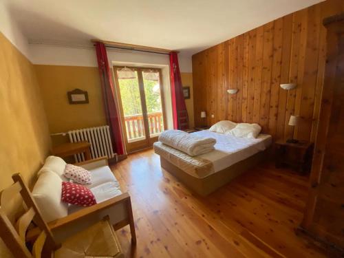 a bedroom with a bed and a couch and a window at Chez Izaline au Chalet de segure in Ristolas