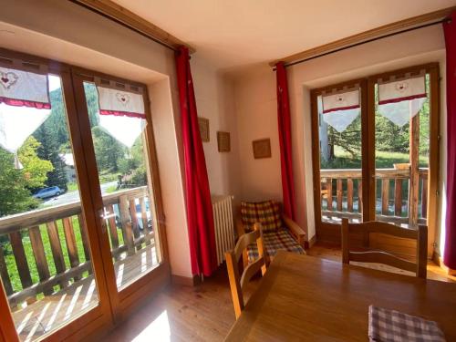 a room with two large windows and a wooden table at Chez Izaline au Chalet de segure in Ristolas