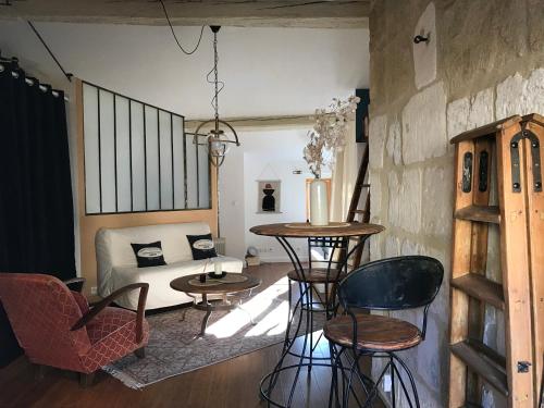 ein Wohnzimmer mit einem Sofa, einem Tisch und Stühlen in der Unterkunft Sacré coeur de ville in Lunel