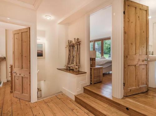 een kamer met houten deuren en een slaapkamer bij Clotted Cream Cottage: Countryside calm: Close to beach: Dartmouth: Devon in Dartmouth