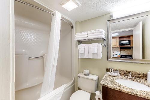 La salle de bains est pourvue de toilettes, d'un lavabo et d'un miroir. dans l'établissement Compass Cove 655, à Myrtle Beach