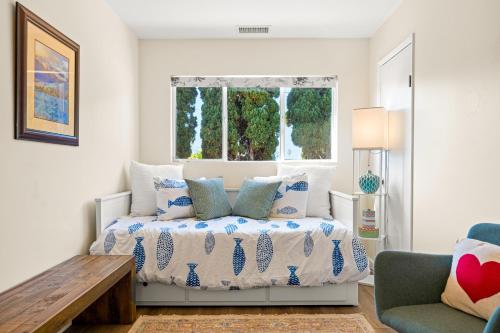 a bedroom with a bed with pillows and a window at Hummingbird Haven in Santa Barbara