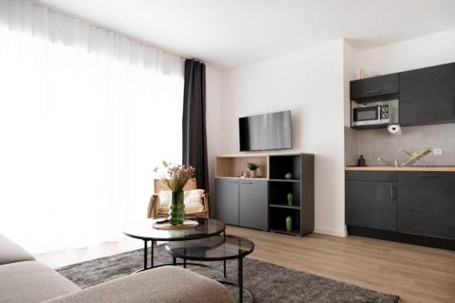 ein Wohnzimmer mit einem Sofa und einem Tisch in der Unterkunft Schicke Apartments in Osnabrück I private Parkplätze I home2share in Osnabrück