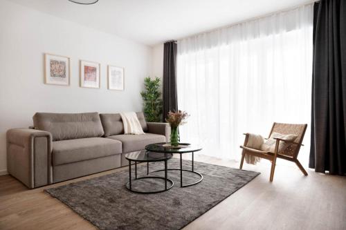 Schicke Apartments in Osnabrück I private Parkplätze I home2share في أوسنابروك: غرفة معيشة مع أريكة وطاولة