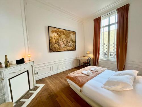 1 dormitorio con 1 cama grande y chimenea en Champagne des Anges - Proche Cathédrale de Reims, en Reims