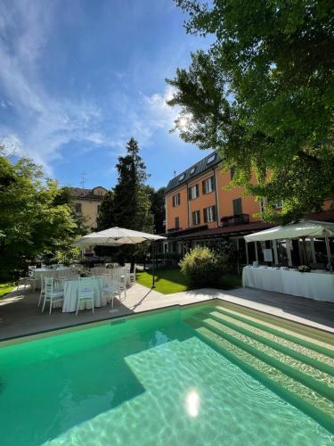 a swimming pool with a table and chairs at Hotel Milano Pool & Garden in Salice Terme