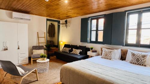 a bedroom with a bed and a living room at Sé Velha Suites in Coimbra