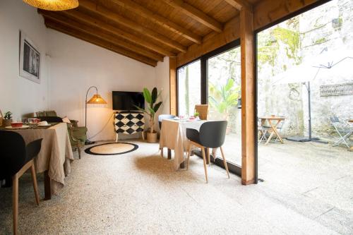 uma sala de estar com uma mesa e cadeiras e uma televisão em Sé Velha Suites em Coimbra
