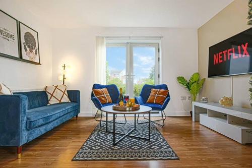 a living room with a blue couch and a table at Stylish City Centre Apartment with Free Parking, Fast W-fi, Smart TV and Balcony by Yoko Property in Chelmsford