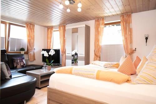 a bedroom with a bed and a living room at Hotel Restaurant Amadeus in Bad Hindelang