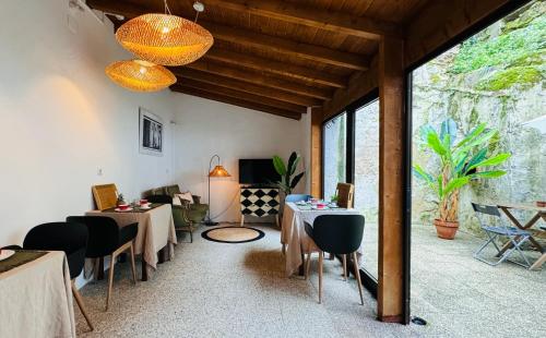 um quarto com mesas e cadeiras e uma grande janela em Sé Velha Suites em Coimbra