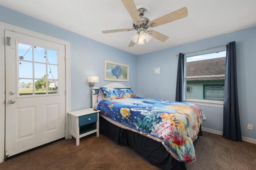 een slaapkamer met een bed en een plafondventilator bij Spacious 10 Bed, Steps to Beach, Private Pool, Yard, Grill in South Padre Island