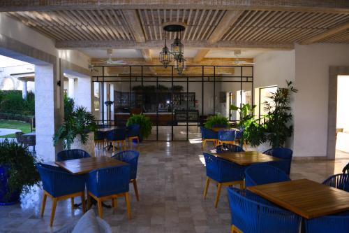 a restaurant with wooden tables and blue chairs at Casa Itzae La Luminaria Dog Friendly in San Miguel de Allende