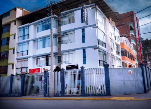 Ein weißes Gebäude mit einem Zaun davor. in der Unterkunft Real House Cusco in Cusco