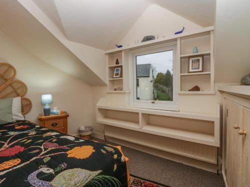 a bedroom with a bed and a window at Still Waters in Ulverston