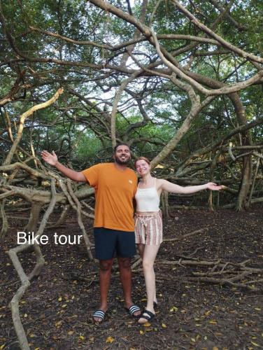 a man and woman standing in front of a tree at Song Ngư Riverside Homestay in Can Tho