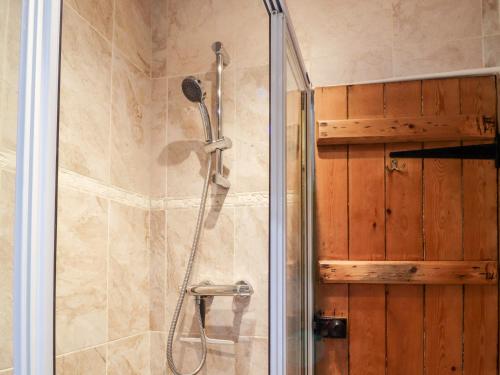 a shower with a glass door in a bathroom at Yate Cottage in Oxenhope