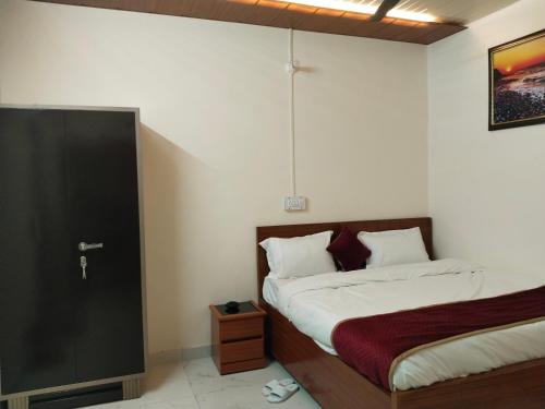 1 dormitorio con 2 camas y puerta a una habitación en JMD 13 Hotel en Gurgaon