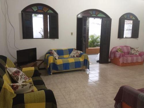 a living room with two couches and two windows at Casa de Praia em Itaparica in Itaparica