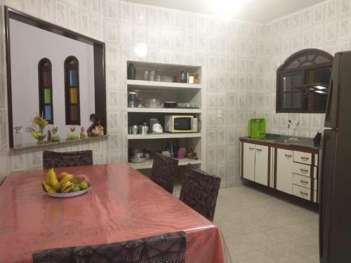 a kitchen with a table with a bowl of fruit on it at Casa de Praia em Itaparica in Itaparica