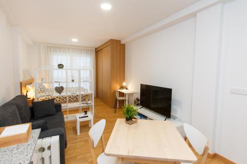 sala de estar con sofá y mesa en Apartamentos Coruña Vip Centro, en A Coruña