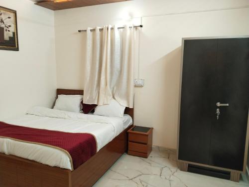 Schlafzimmer mit einem Bett, einem Fenster und einer Tür in der Unterkunft JMD 13 Hotel in Gurgaon