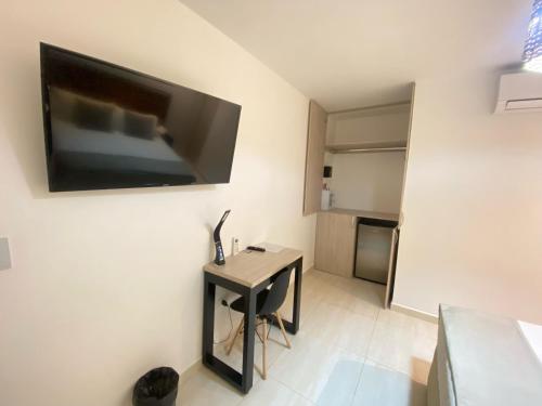 a room with a small table and a television on the wall at Maidy Luxury Hotel in Medellín