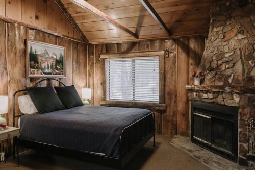 2411 - Oak Knoll Duplex Studio #14 cabin في بيغ بير لاكي: غرفة نوم بسرير ومدفأة