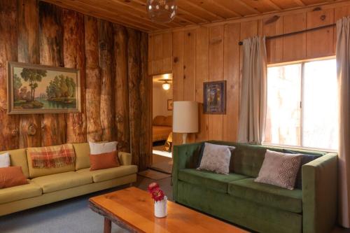 a living room with a green couch and a table at 2407 - Oak Knoll #9 cabin in Big Bear Lake