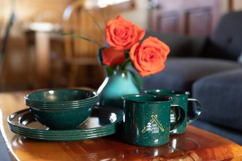 a table with two green cups and a vase with roses at 2412 - Oak Knoll Studio with Jacuzzi #15 cabin in Big Bear Lake