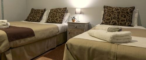 a hotel room with two beds and a night stand at Boutique Vineyard and Wine Lodge in Maipú