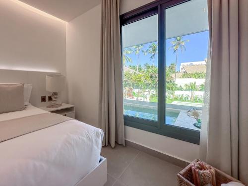 a bedroom with a large window with a view of a pool at Fantastic brand new beach home in Punta Cana