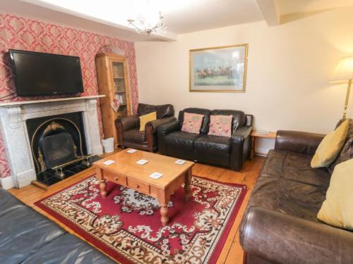 a living room with a couch and a fireplace at Manor Farmhouse in Filey