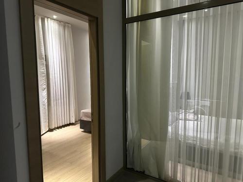 - une grande fenêtre en verre dans une chambre avec une table dans l'établissement Soli centr apartman, à Mezitli
