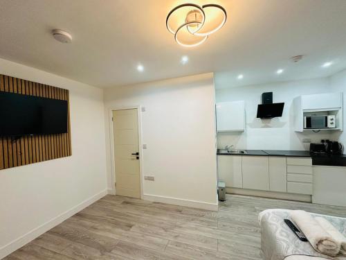 a white room with a kitchen with a sliding door at SK Heathrow Hotel in Hayes