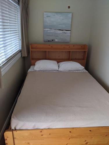 a bed in a bedroom with a wooden bed frame at Safari Beach Resort in Osoyoos