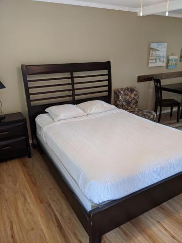 a bedroom with a large bed with white sheets at Safari Beach Resort in Osoyoos