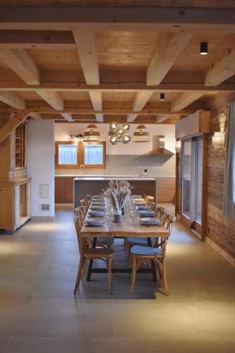une salle à manger avec une grande table et des chaises en bois dans l'établissement CHEZ NONNA - Charmant demi-chalet à la montagne, à Notre-Dame-de-Bellecombe